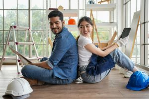 Happy carpenters designing and planing wood products in workshop