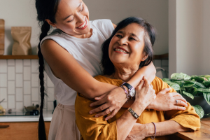 mothe and daughter bonding hugging in the kitchen