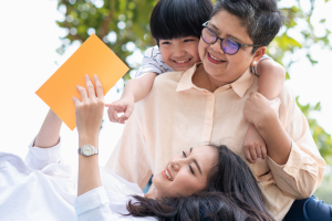 mother with daughter and grandson at a park reading book