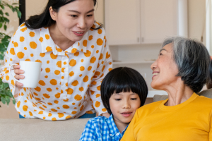 3 ladies grandmother, mother and daughter in a living room sitting on sofa talking